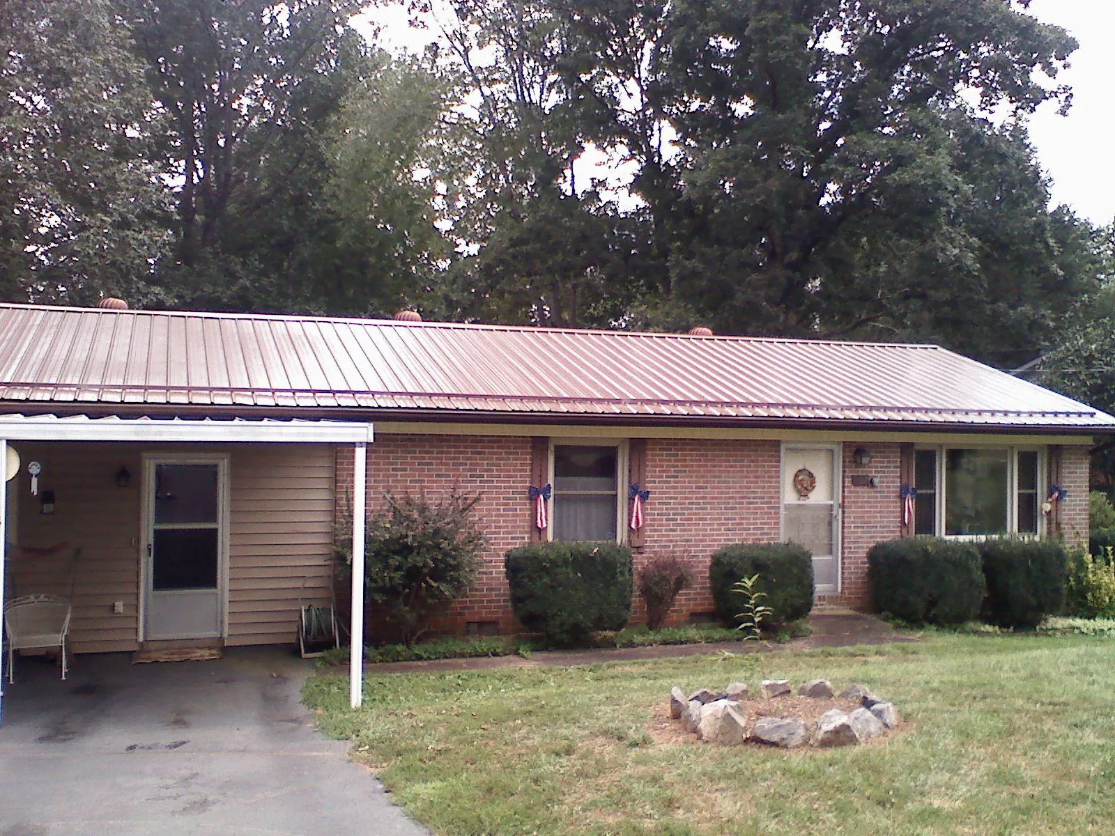 Bronze metal roof and carport on a brick ranch home — Roof Repair work by our crew in Windsor